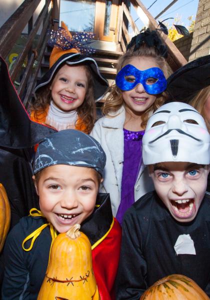 Bambini in costumi di Halloween con zucche, sorridenti e divertenti.