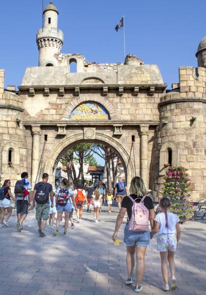 Ingresso di un parco divertimenti con castello e personaggi.