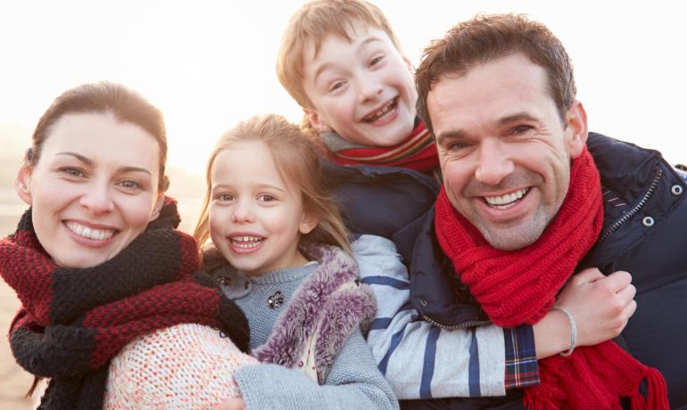 Famiglia felice all'aperto con sciarpe colorate in una giornata soleggiata.