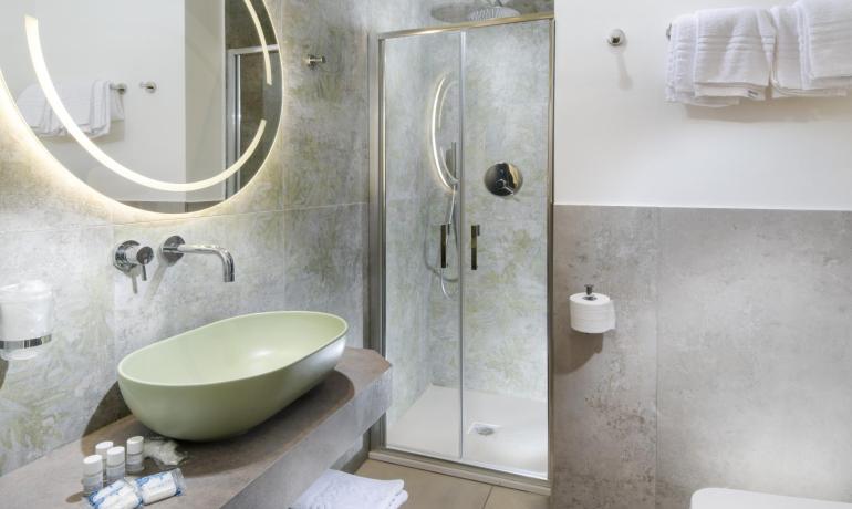 Bagno moderno con doccia e lavabo elegante.